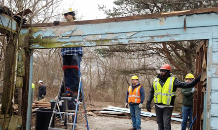 Workers reclaim lumber and building materials from a vacant home in Gary. The reclaimed materials will be resold or donated to local groups converting local blight into an economic benefit for the community.